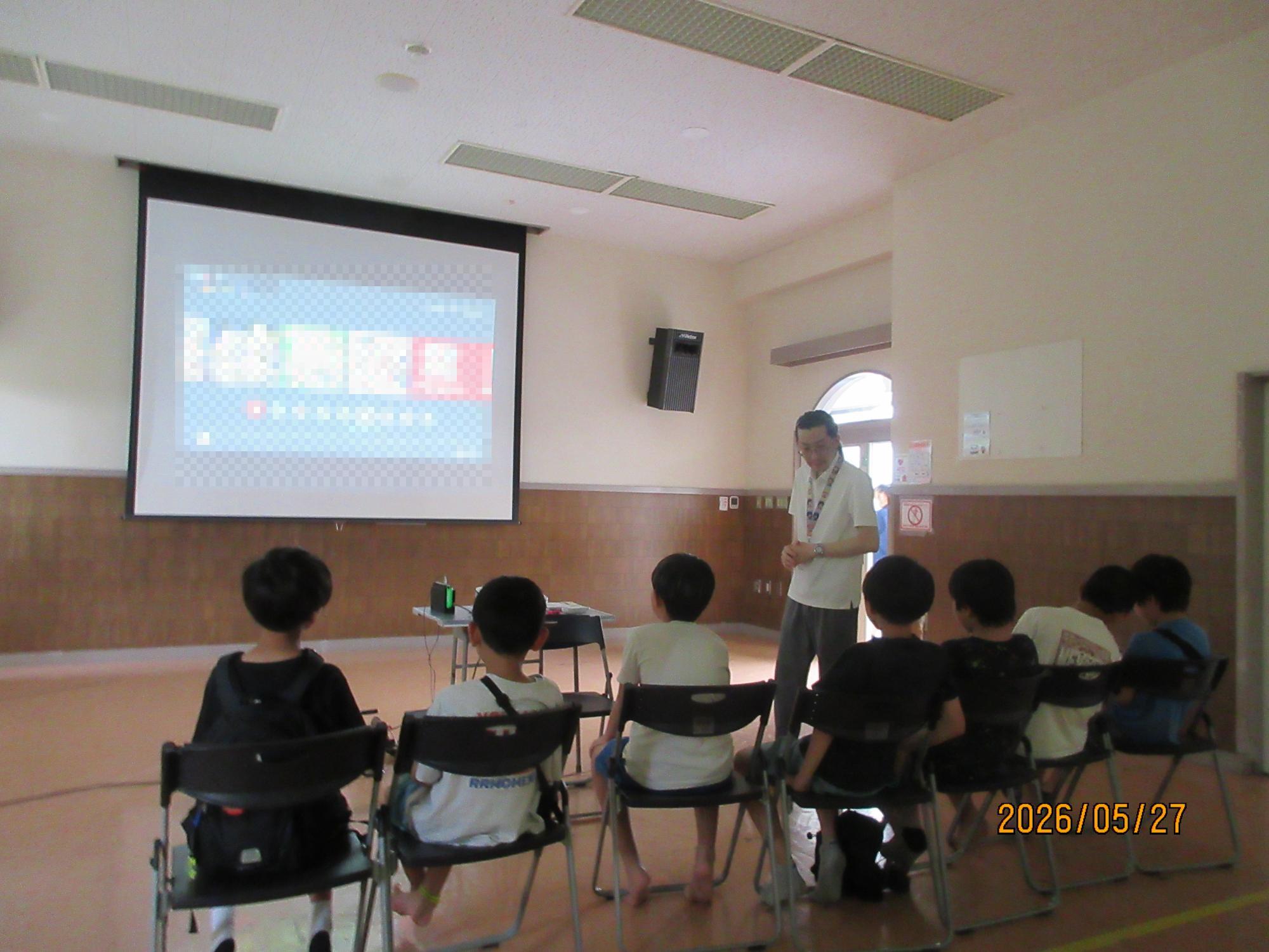 子ども達が大きな画面でゲームをしているところの写真
