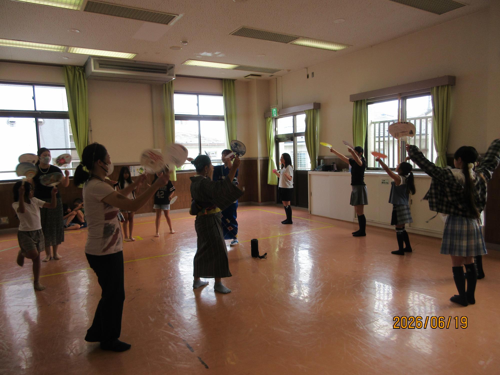 集会室で盆踊りを踊っているところの写真