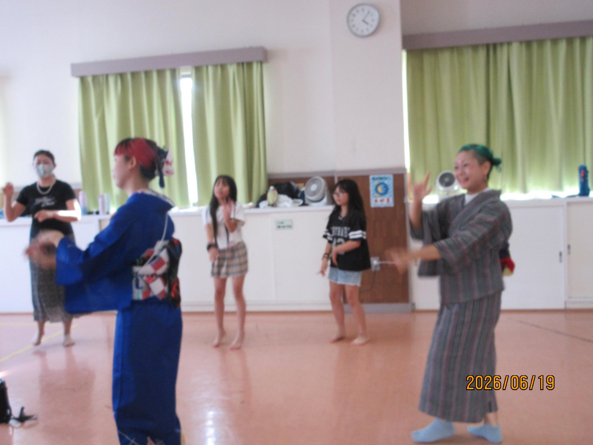 集会室で盆踊りを踊っているところの写真