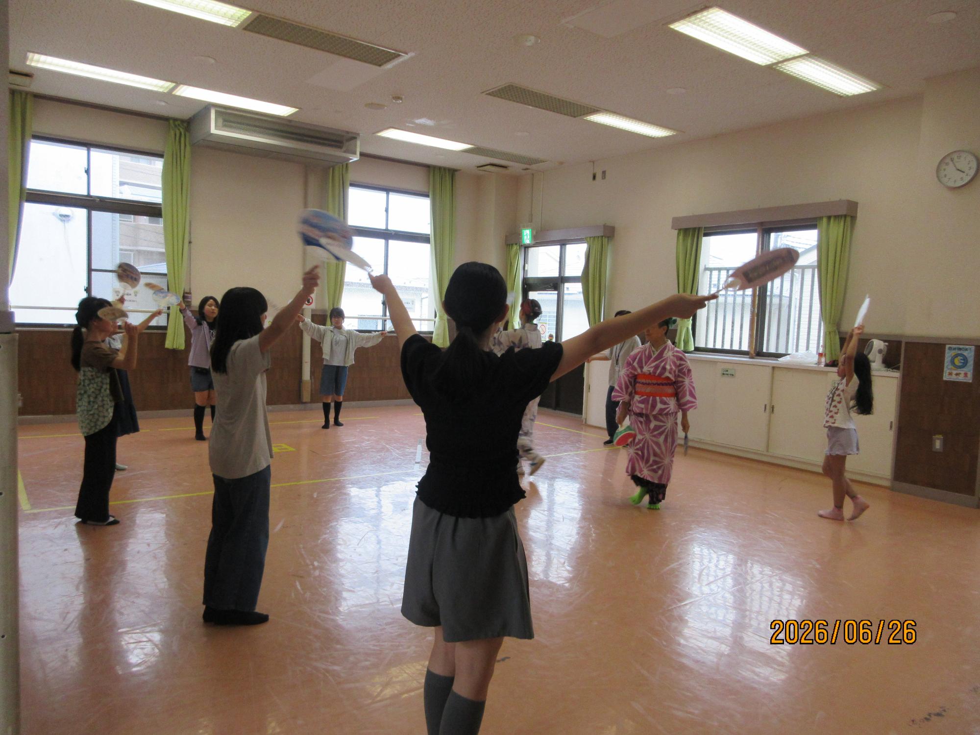 集会室で盆踊りを踊っているところの写真