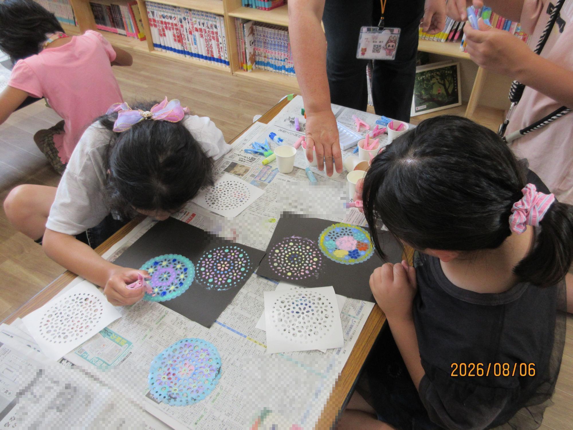 図書室で夜空の花火アート工作をしている様子