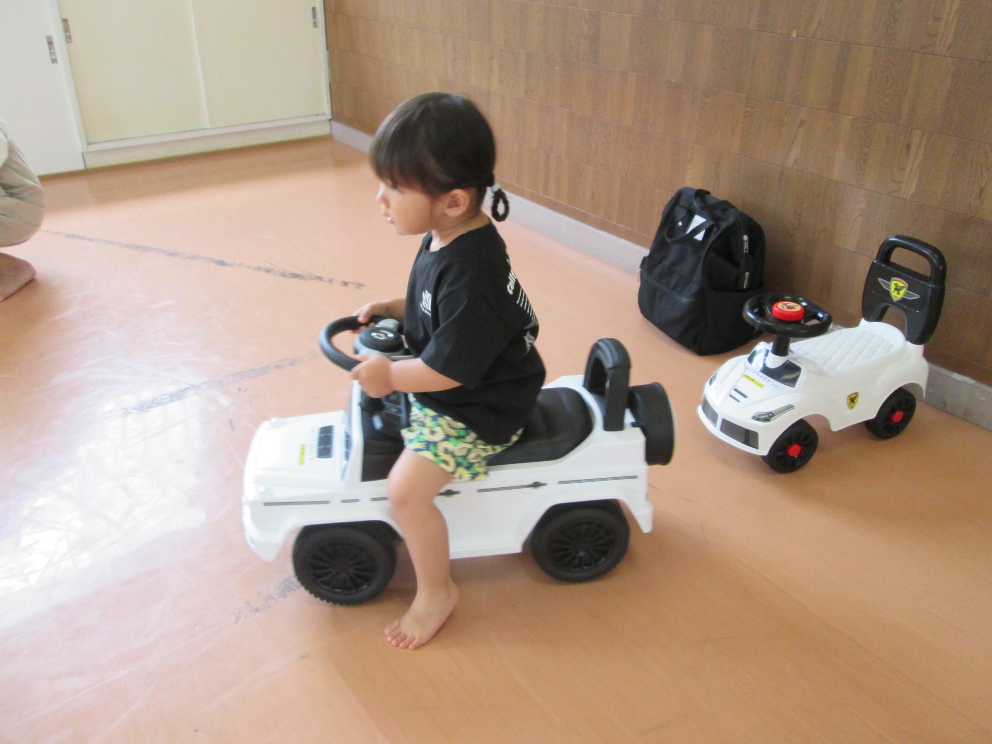 集会室でコンビカーに乗って遊んでいるところの写真