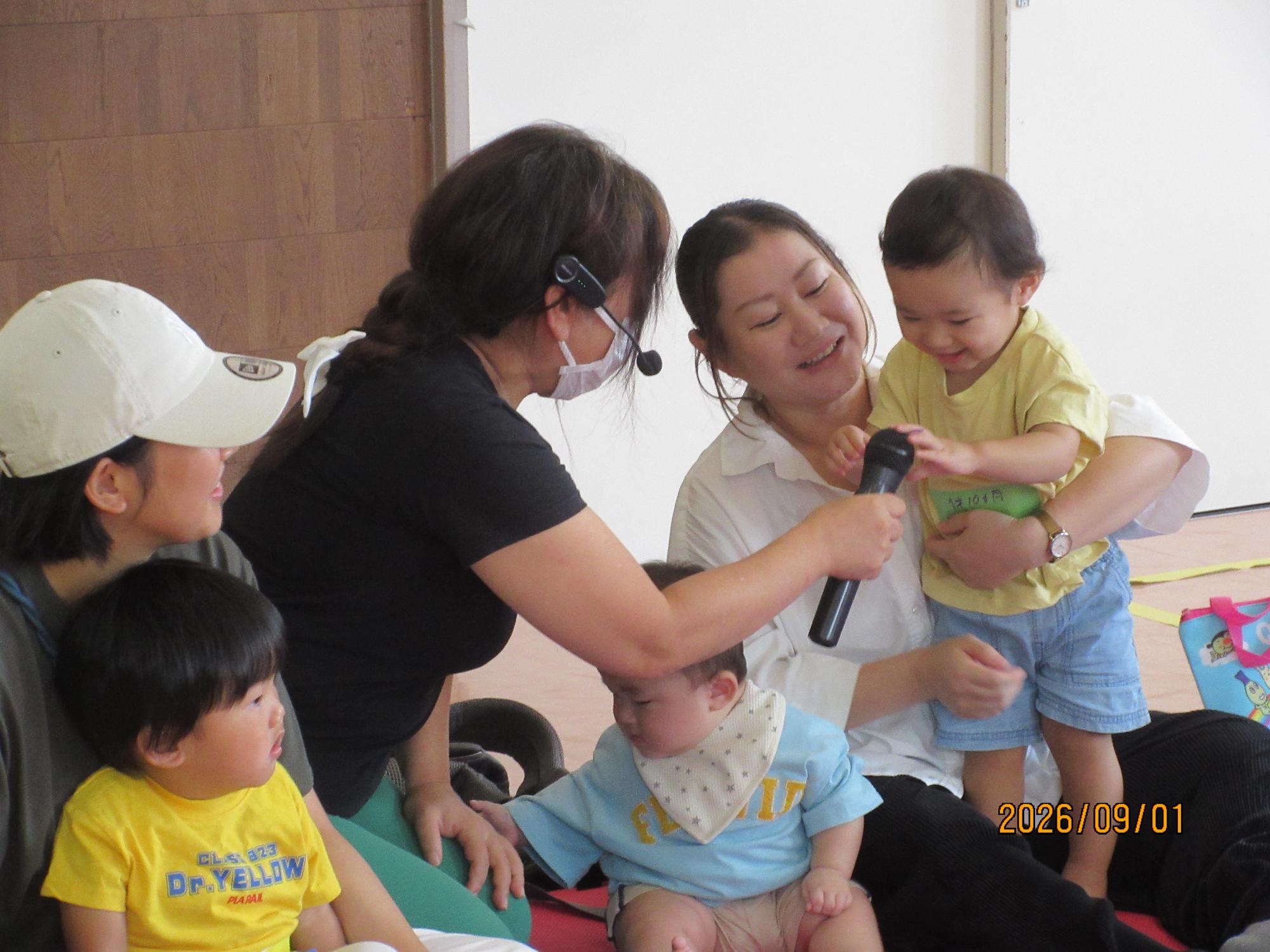 集会室で乳幼児親子が行事に参加している様子