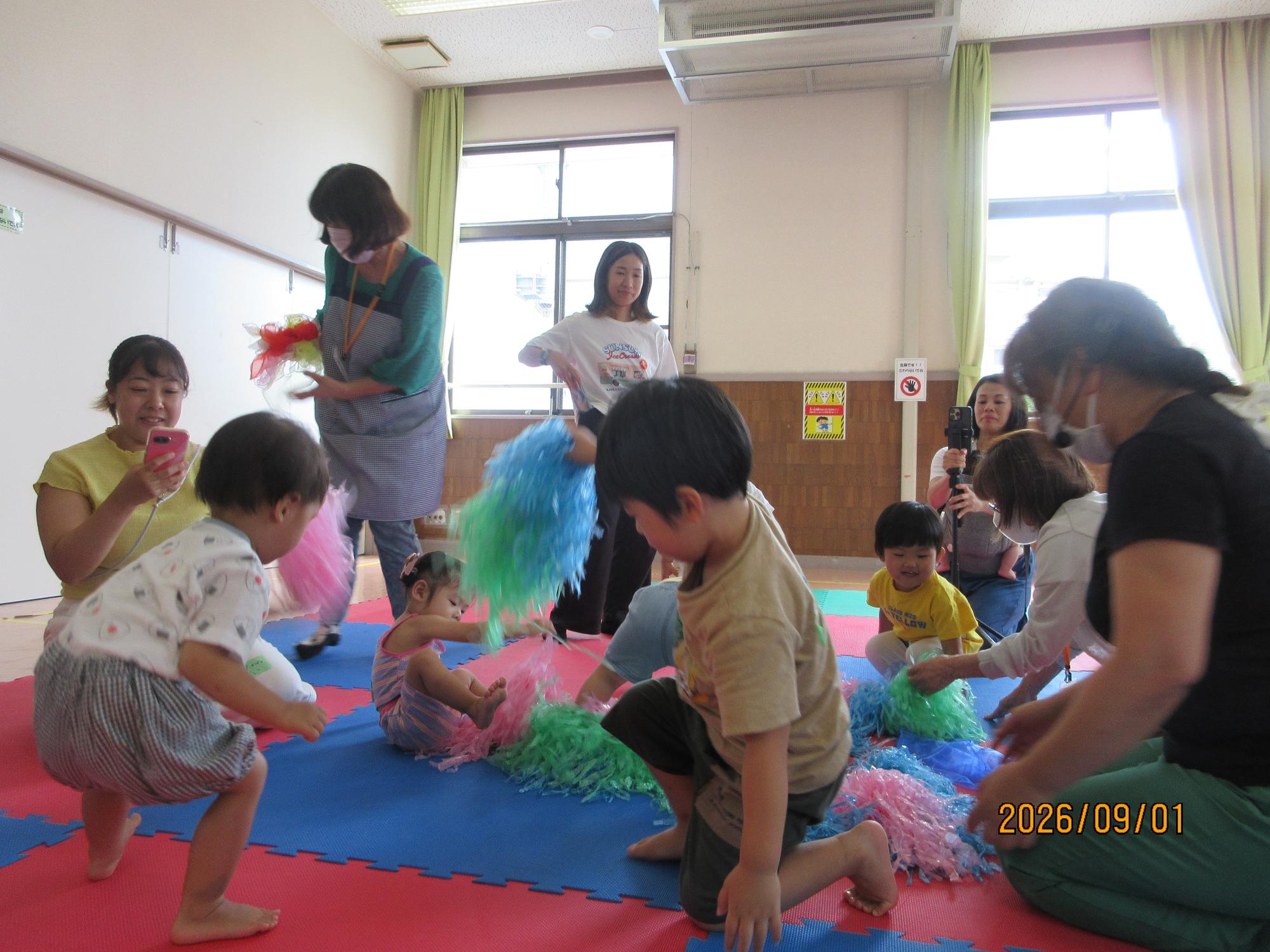 集会室で乳幼児親子が行事に参加している様子
