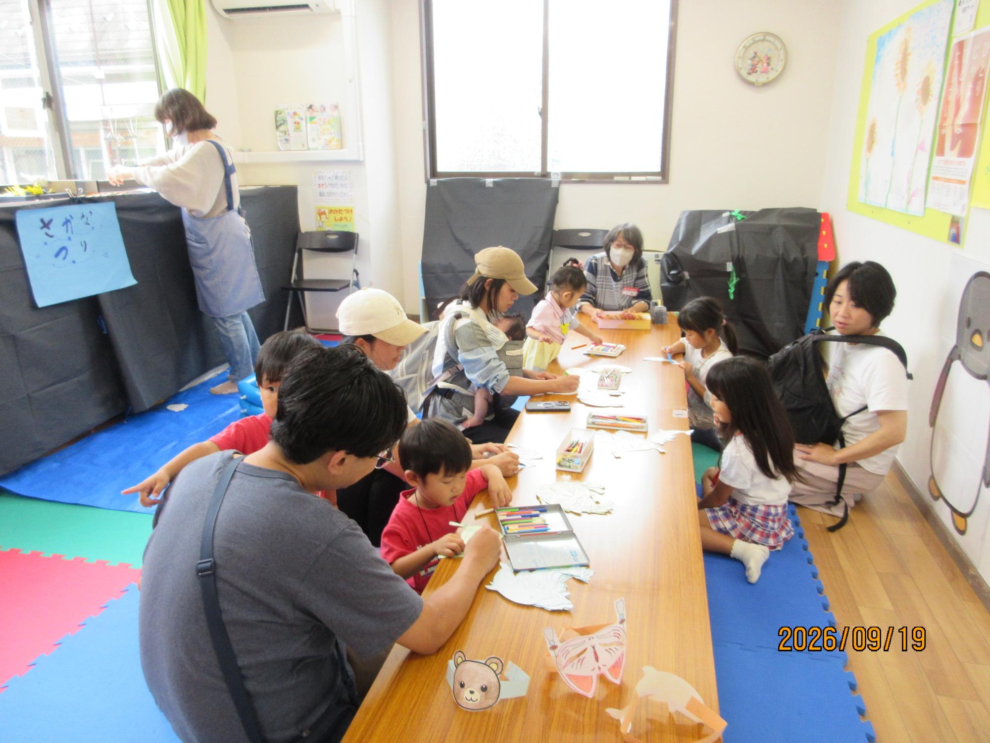幼児親子がお祭りで工作作りをしているところの写真
