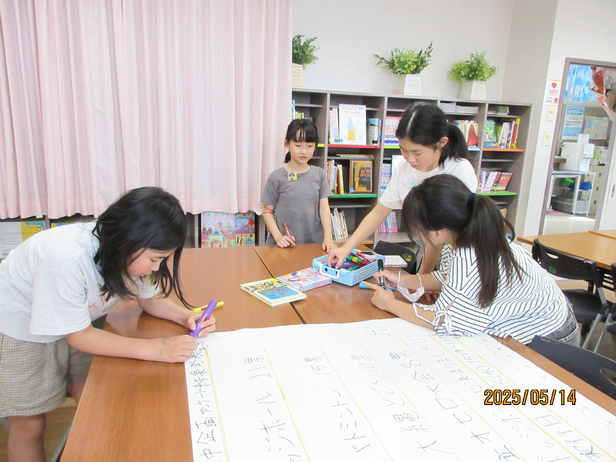 学習室でこども会議でポスターづくりをしているところの写真