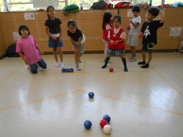 チームにわかれてボッチャの対戦をする小学生7人の画像