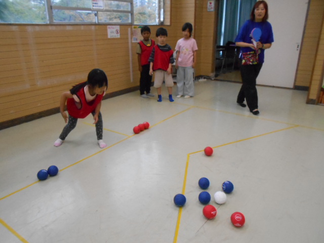 女の子がボッチャのボールを投げている写真