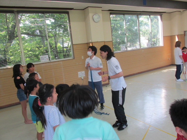 小学生たちにダブルダッチのやり方を説明する講師の方々の写真