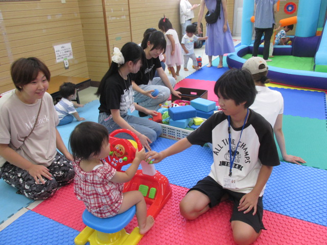 ボランティアの小・中学生が幼児と遊んでいる様子