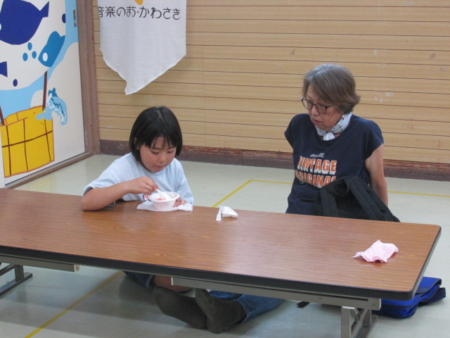 かき氷を食べている女の子を祖母が見ている写真