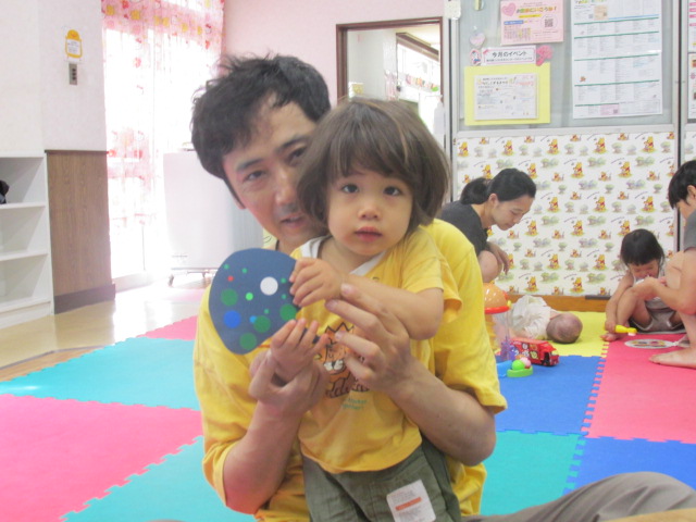 父親と幼児が作品を見せている写真