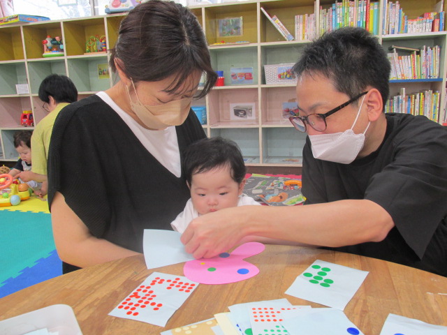 親子でシール貼りをしている写真