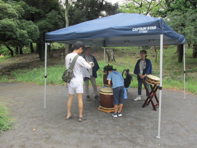 屋外で太鼓体験をしている写真