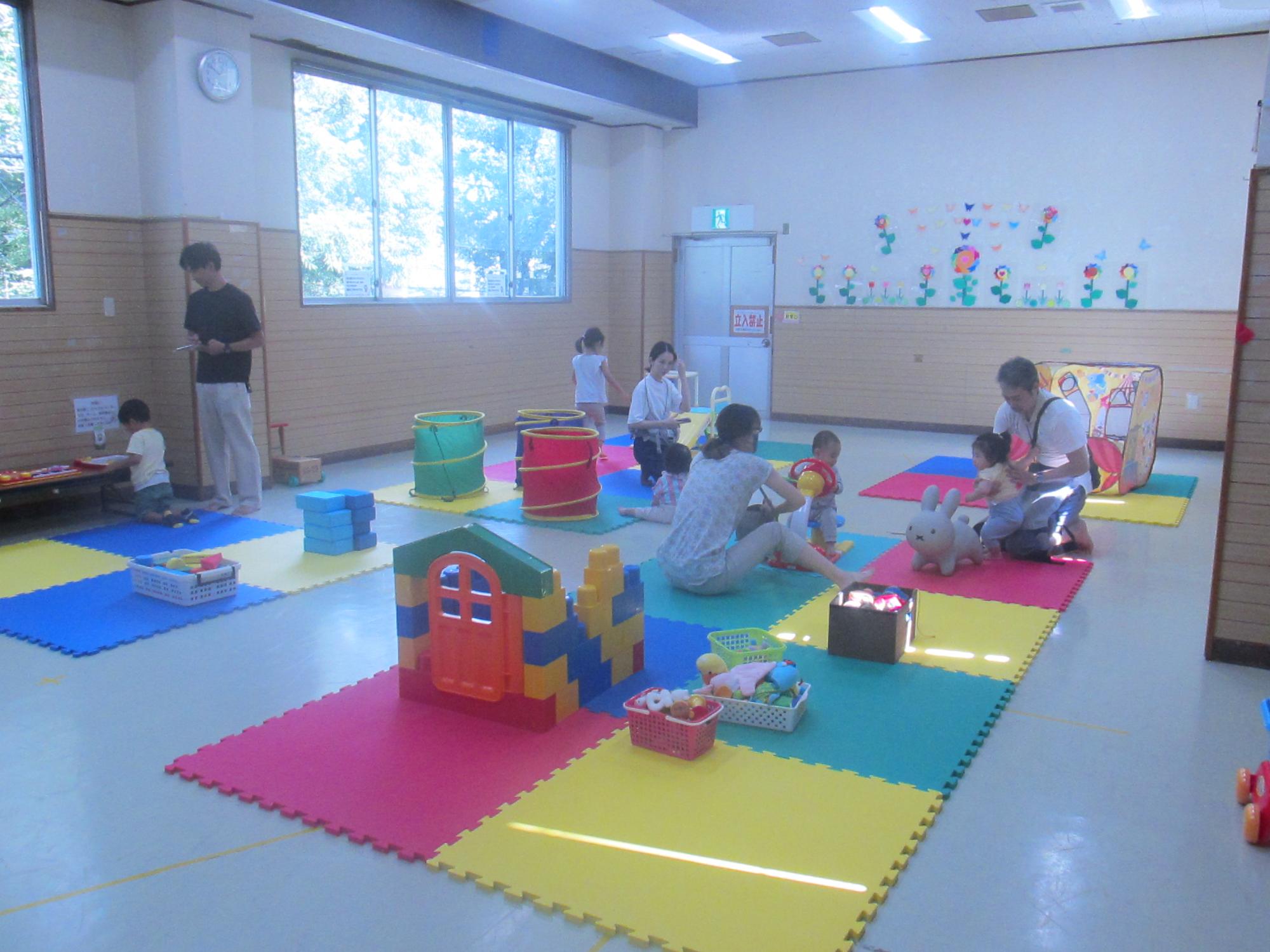 小さな滑り台やたくさんのおもちゃが配置されている部屋全体を写した写真