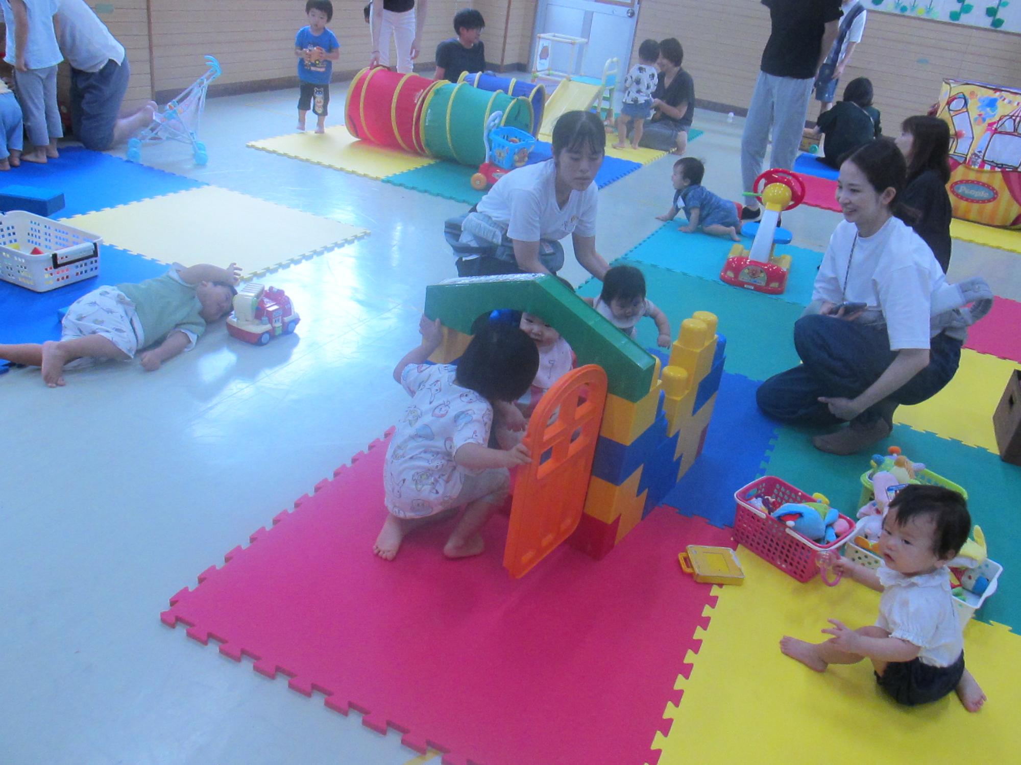 大きなレゴのお家で遊んでいる幼児の写真