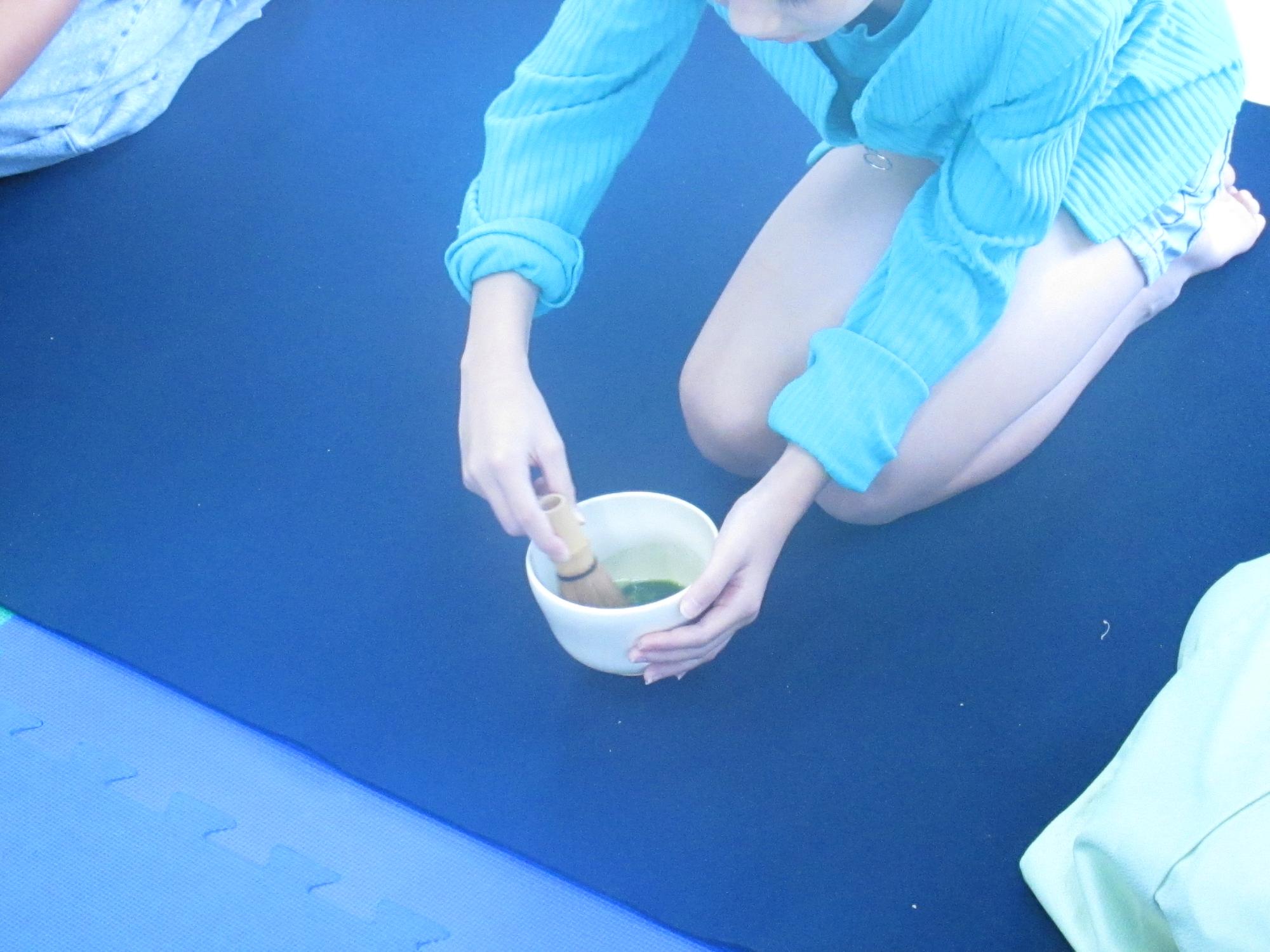 子どもがお茶をたてている写真