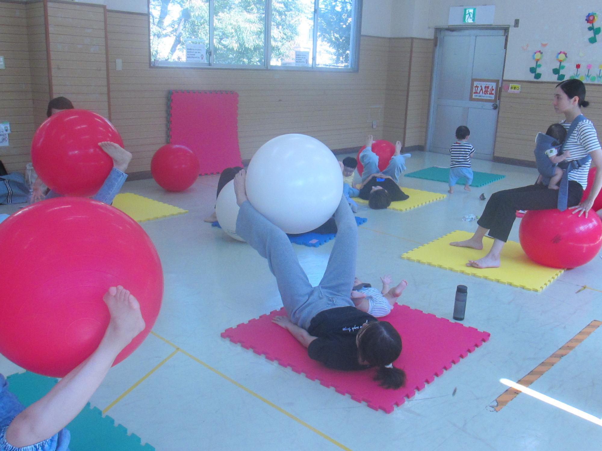 バランスボールを足で挟んで持ち上げている写真