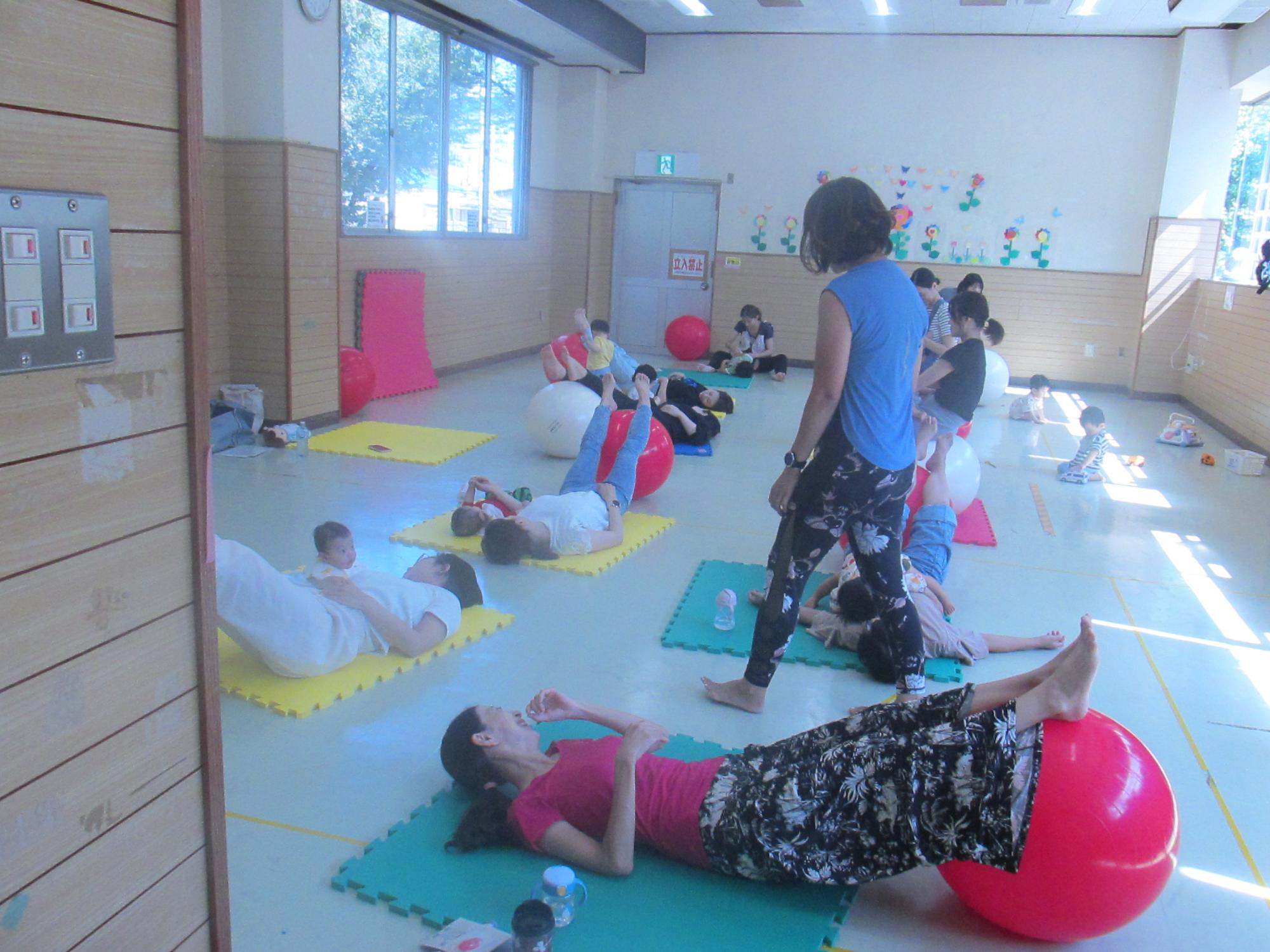 女性がバランスボールに足を乗せてクールダウンしている写真