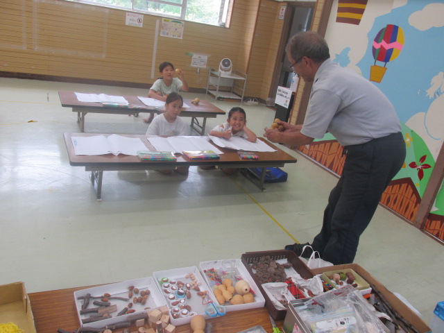 工作の説明をするスタッフの話を聞いている子どもたちの写真