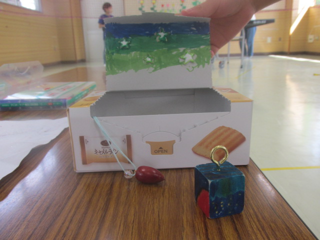 どんぐりネックレスと空き箱や木材を加工した作品の写真