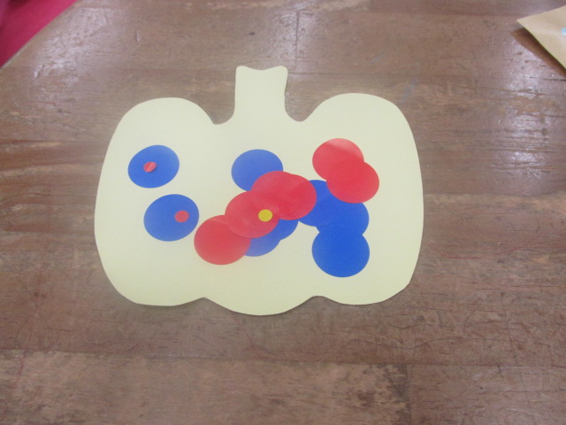 黄色地に赤と青などのシールが張られたカボチャの紙の写真