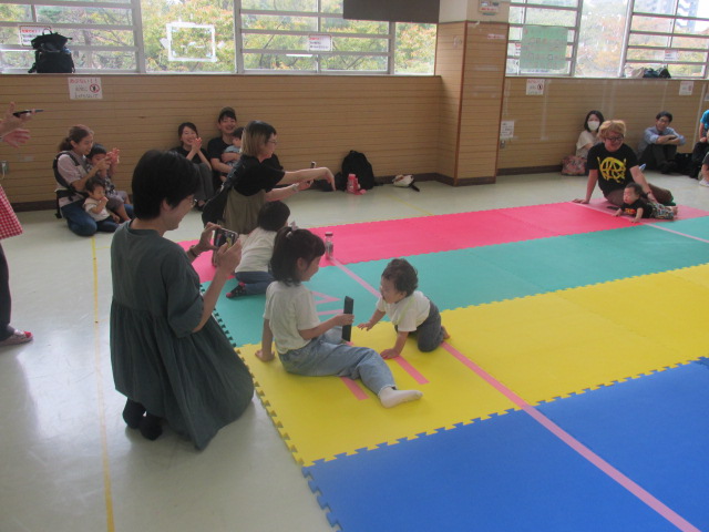 ゴールをしてお姉ちゃんに迎えられている赤ちゃんの写真