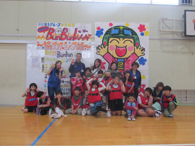 行事の看板と大きなこぶんたパネルの前で撮った集合写真