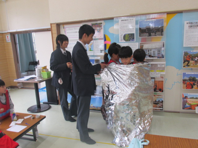 防災アルミシートにくるまっている子どもたちの写真