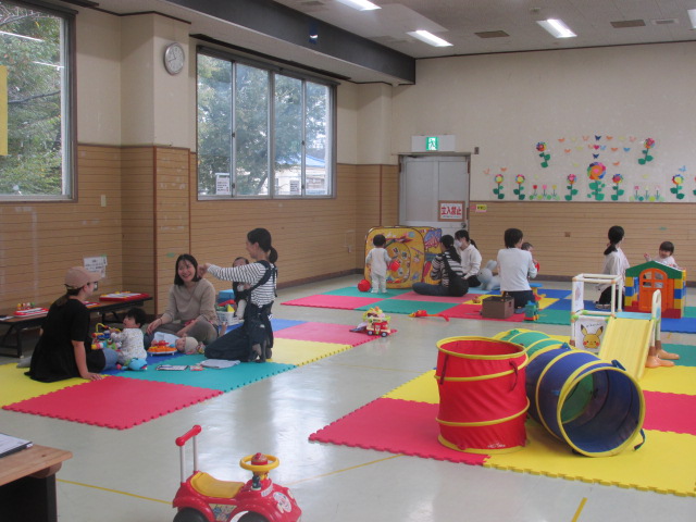 室内のボールプールやすべり台などさまざまなおもちゃで複数の親子が遊んでいる写真