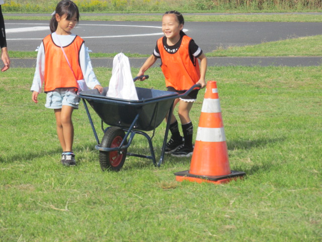 運搬用の手押し一輪車で女の子たちが物を運んでいる写真