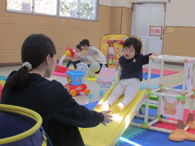 すべり台で遊んでいる親子の写真