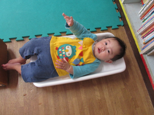 乳児が仰向けになって体重計に乗っている写真