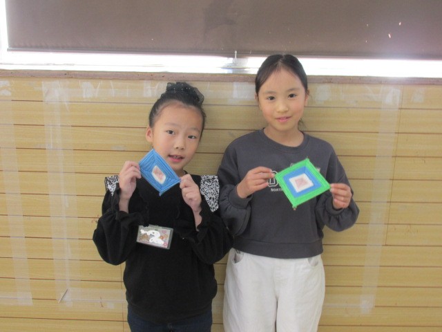 作品を持って立つ二人の女の子の写真