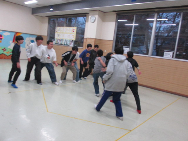 中学生たちが反対側に渡ろうとするのをオニたちが止めようとしている写真