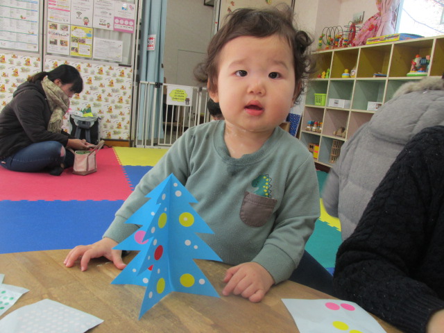 クリスマスツリーと一緒に幼児が写っている写真