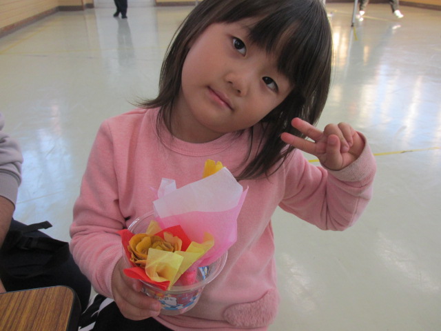 女の子がブーケのカップを持ってポーズをとっている写真