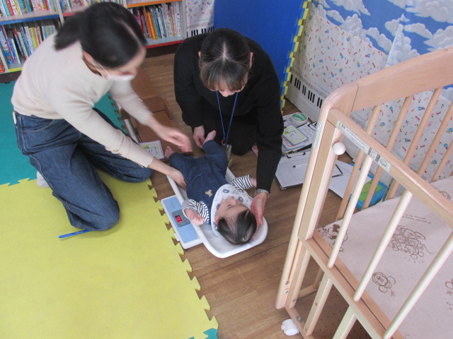 体重計の上で横になっている幼児の写真