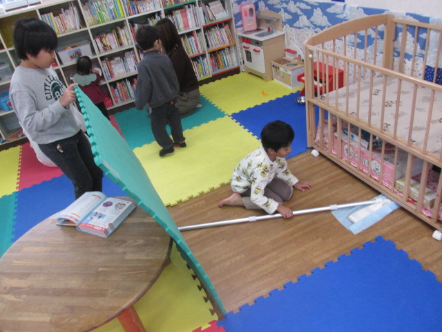 幼児室を小学生が清掃している写真