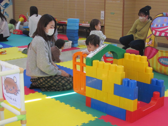 大きなブロックの家で遊んでいる幼児の写真