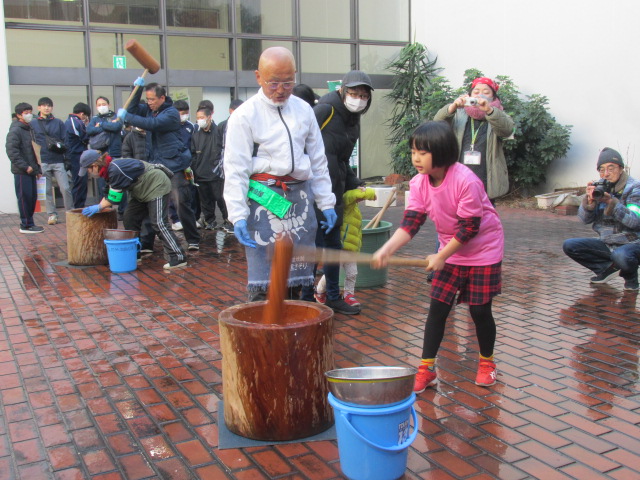 女の子がもちつきをしている写真