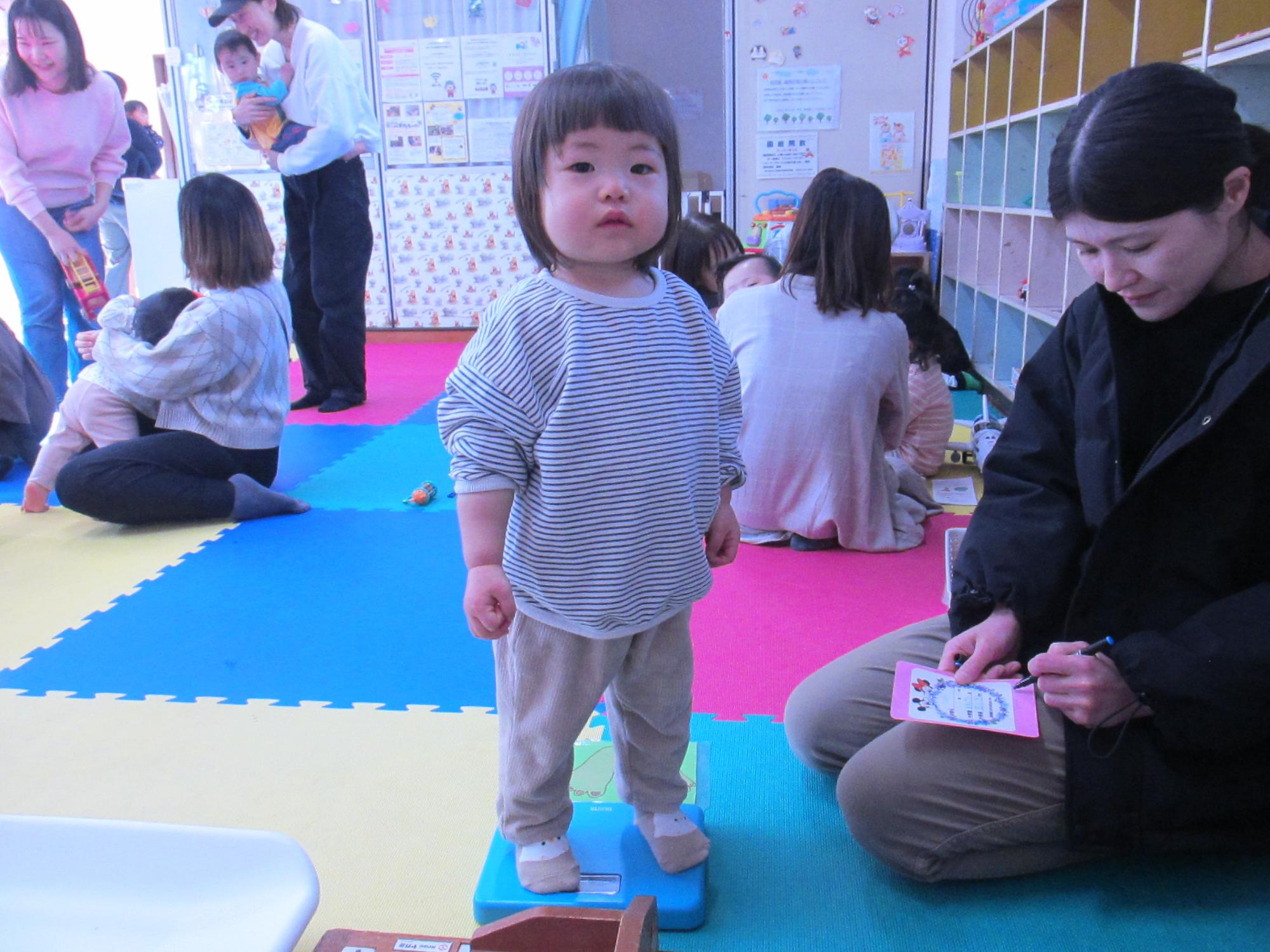 体重計の上に立っている幼児の写真