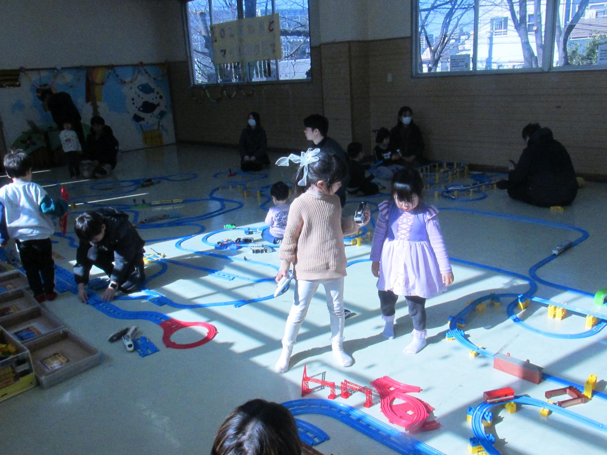 部屋いっぱいにレールを敷いて遊んでいる写真
