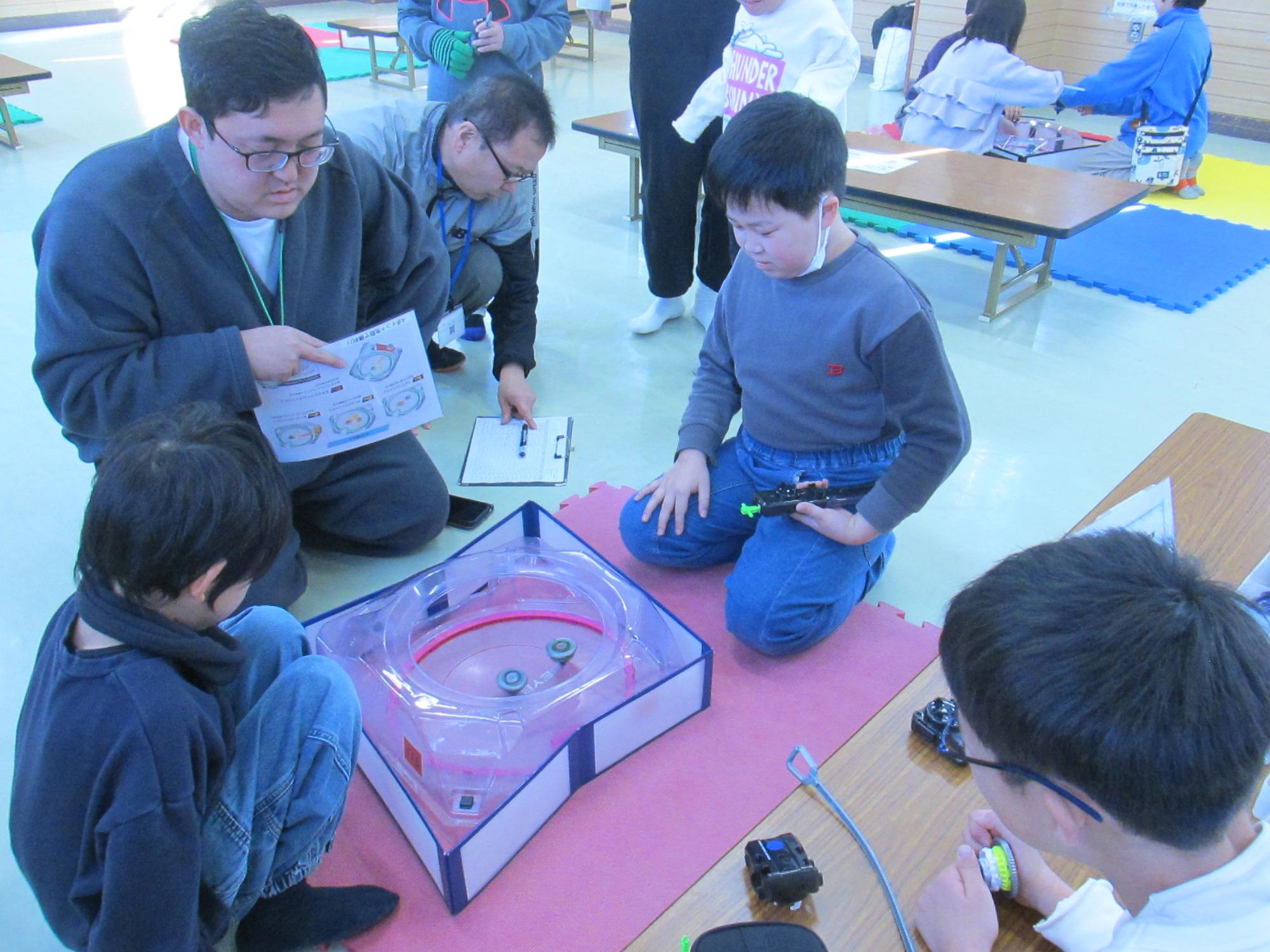 ベイブレードの対戦をしている写真