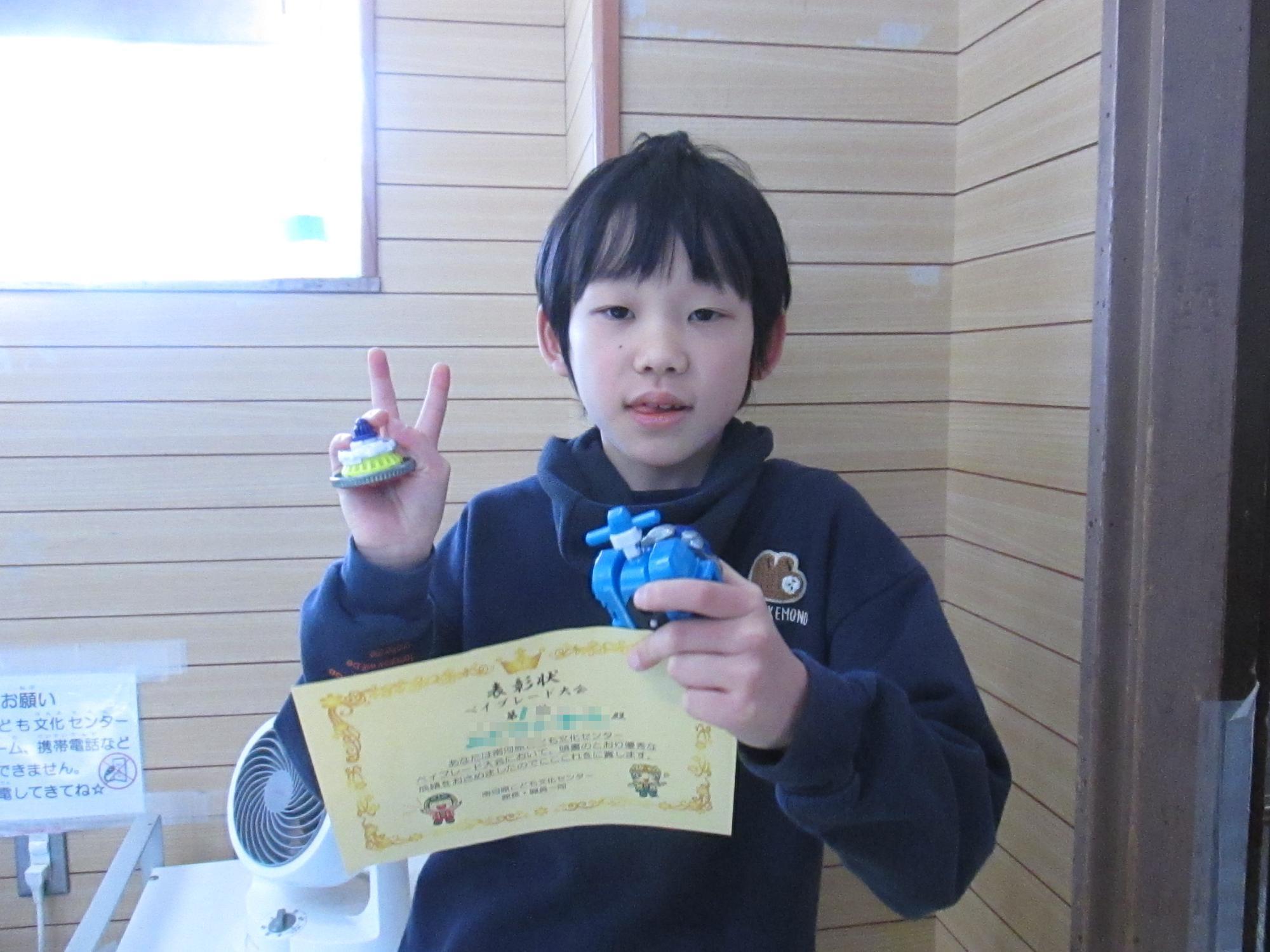 大会で優勝して賞状を持っている男の子の写真