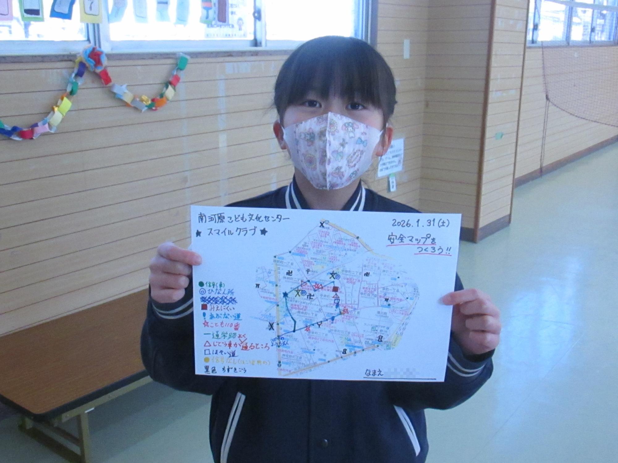 女の子が自分のメモした安全マップを持っている写真