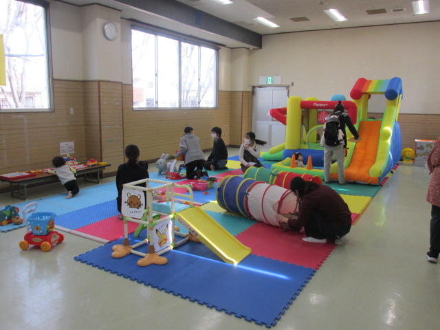 集会室に大型遊具を広げて遊んでいる写真