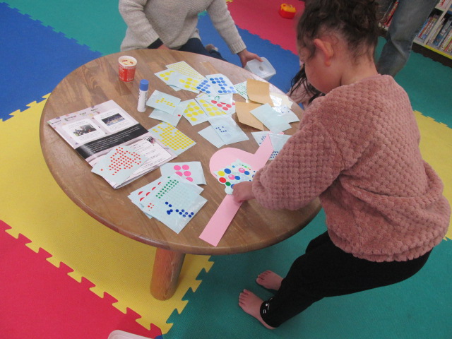 シール貼り工作をしている子どもたちの写真