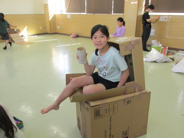 2階建てのダンボールハウスに乗っている女の子の写真