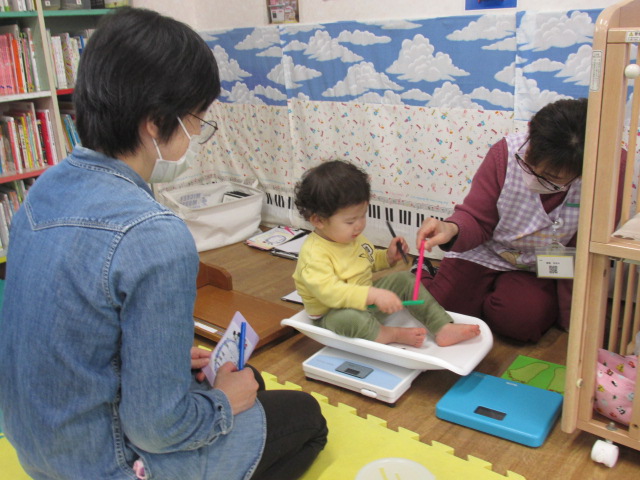 体重計に乗っている幼児の写真